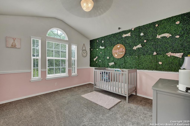 bedroom with vaulted ceiling, carpet, baseboards, and a crib