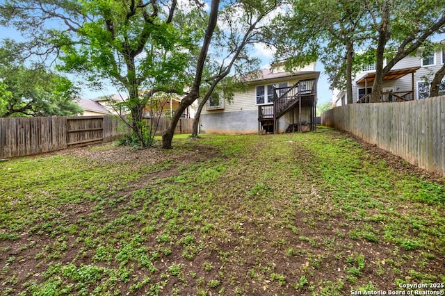 view of yard featuring a fenced backyard and stairs