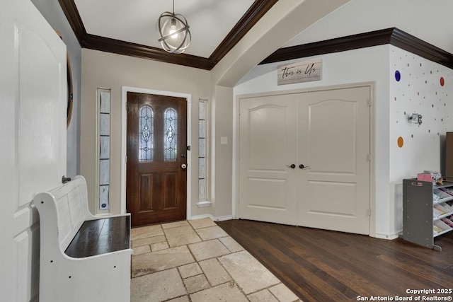 entrance foyer featuring stone tile floors, ornamental molding, and baseboards