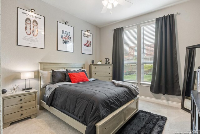bedroom featuring ceiling fan, light carpet, and baseboards