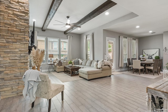 living room featuring recessed lighting, baseboards, light wood finished floors, ceiling fan, and beamed ceiling