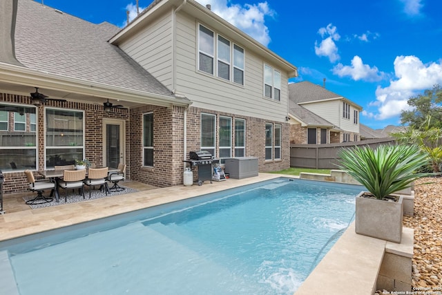 outdoor pool featuring a ceiling fan, a fenced backyard, a patio area, and grilling area