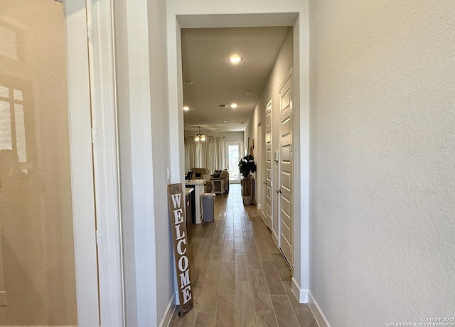 hall with baseboards, dark wood finished floors, and recessed lighting