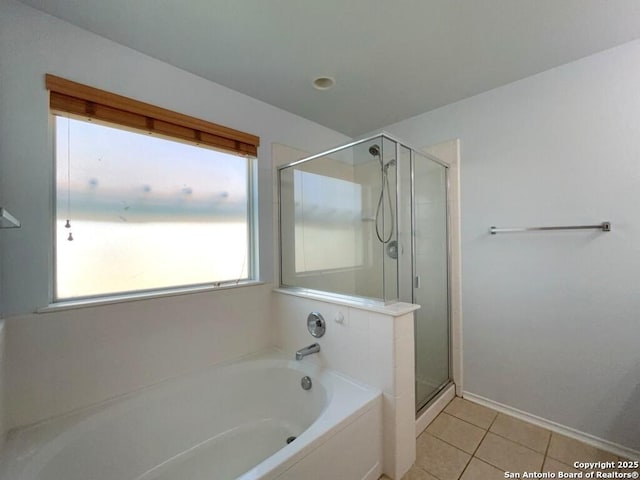 full bathroom with a shower stall, tile patterned flooring, a bath, and baseboards
