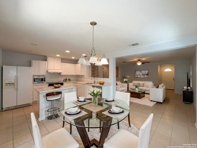 dining space featuring light tile patterned floors, visible vents, ceiling fan with notable chandelier, and recessed lighting