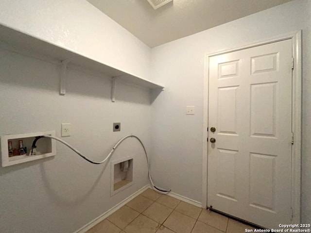 clothes washing area featuring laundry area, hookup for an electric dryer, light tile patterned floors, washer hookup, and baseboards
