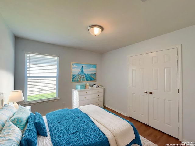 bedroom featuring a closet, wood finished floors, and baseboards