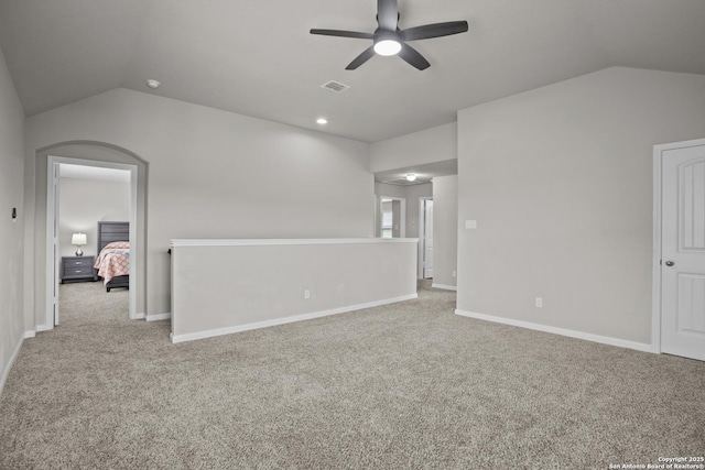 unfurnished room with carpet, a ceiling fan, baseboards, and lofted ceiling