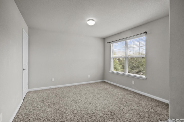 spare room with baseboards and carpet