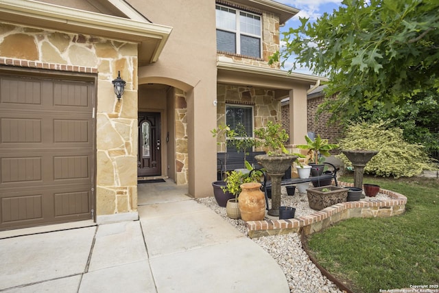 entrance to property featuring stone siding, stucco siding, and a garage