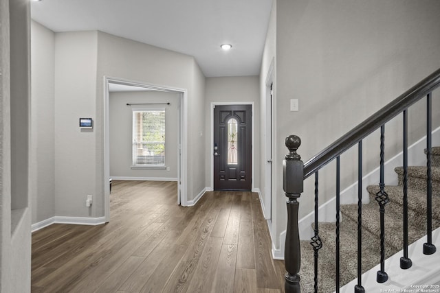 entryway with stairs, baseboards, and wood finished floors