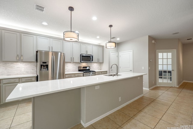 kitchen with stainless steel appliances, light tile patterned flooring, a sink, and visible vents