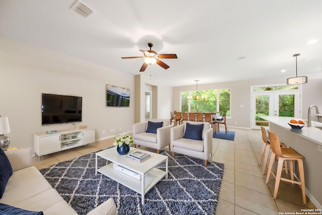 living room featuring a ceiling fan, french doors, light tile patterned floors, baseboards, and visible vents