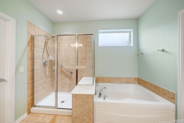 bathroom with a shower stall, tile patterned floors, and a garden tub