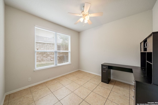 unfurnished office with light tile patterned floors, baseboards, and ceiling fan