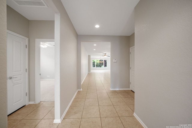 corridor featuring light tile patterned floors, recessed lighting, baseboards, and visible vents