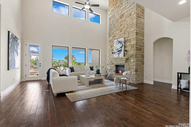 28546 Tristant Rdg, San Antonio, TX 78260 - living area featuring a ceiling fan, a fireplace, a towering ceiling, and dark wood-type flooring