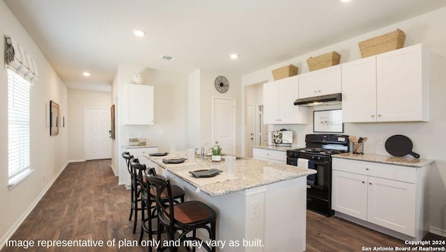 kitchen featuring black range with gas cooktop, light stone counters, dark wood finished floors, a sink, and a kitchen breakfast bar