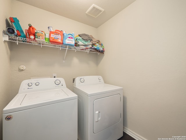 washroom featuring baseboards, washing machine and dryer, laundry area, and visible vents