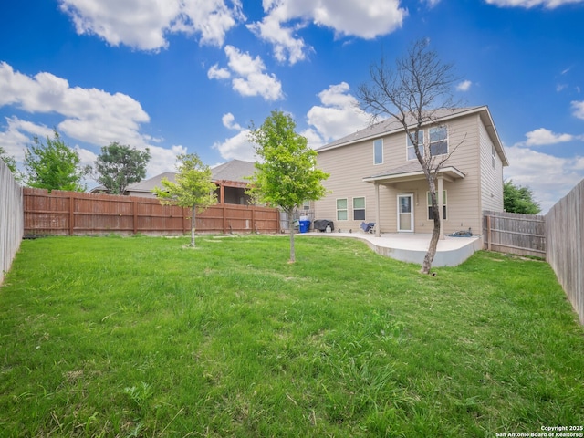 rear view of property featuring a lawn, a patio, and a fenced backyard