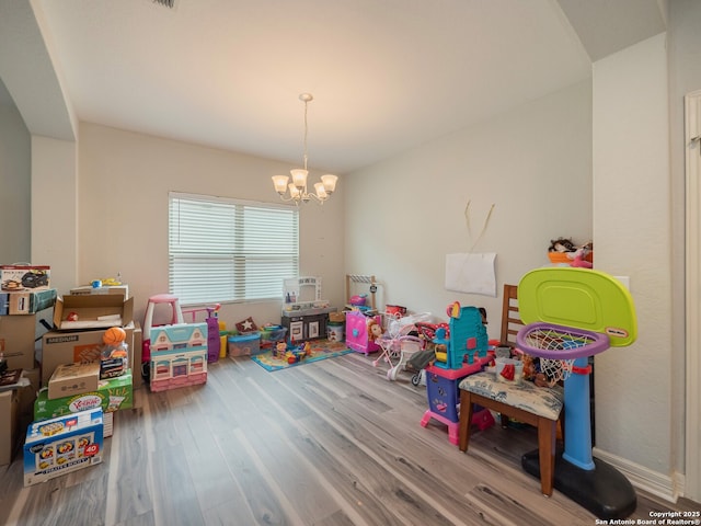 playroom with a chandelier and wood finished floors