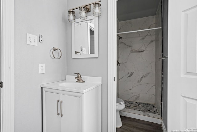 full bath with a marble finish shower, vanity, toilet, and wood finished floors