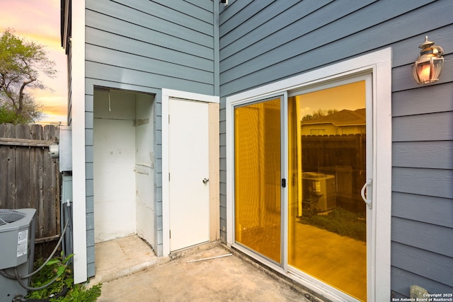 doorway to property featuring fence and cooling unit