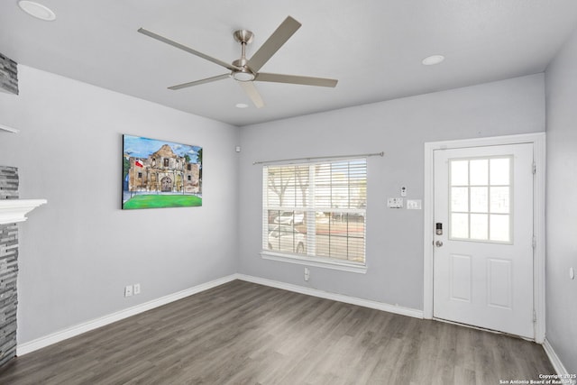 entryway with wood finished floors, a fireplace, baseboards, ceiling fan, and recessed lighting