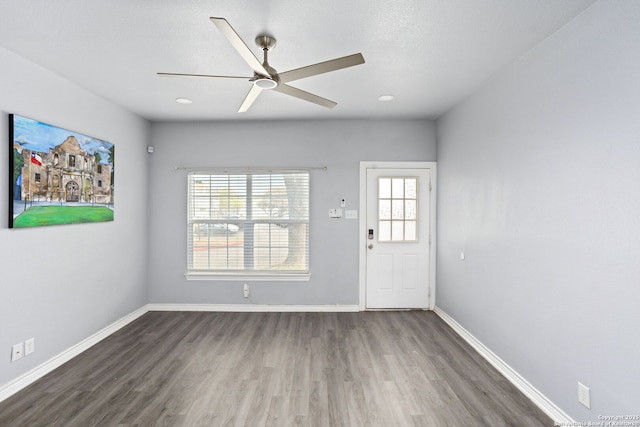 interior space featuring wood finished floors, baseboards, and ceiling fan
