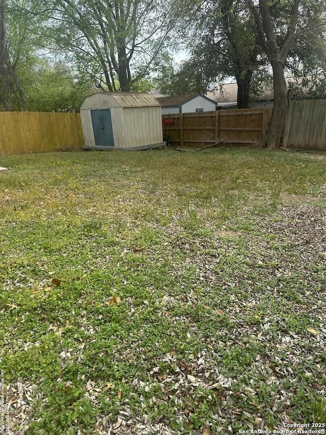 view of yard with an outbuilding, a shed, and a fenced backyard