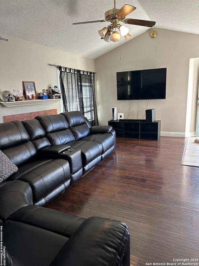 living room with vaulted ceiling, a textured ceiling, baseboards, ceiling fan, and wood finished floors
