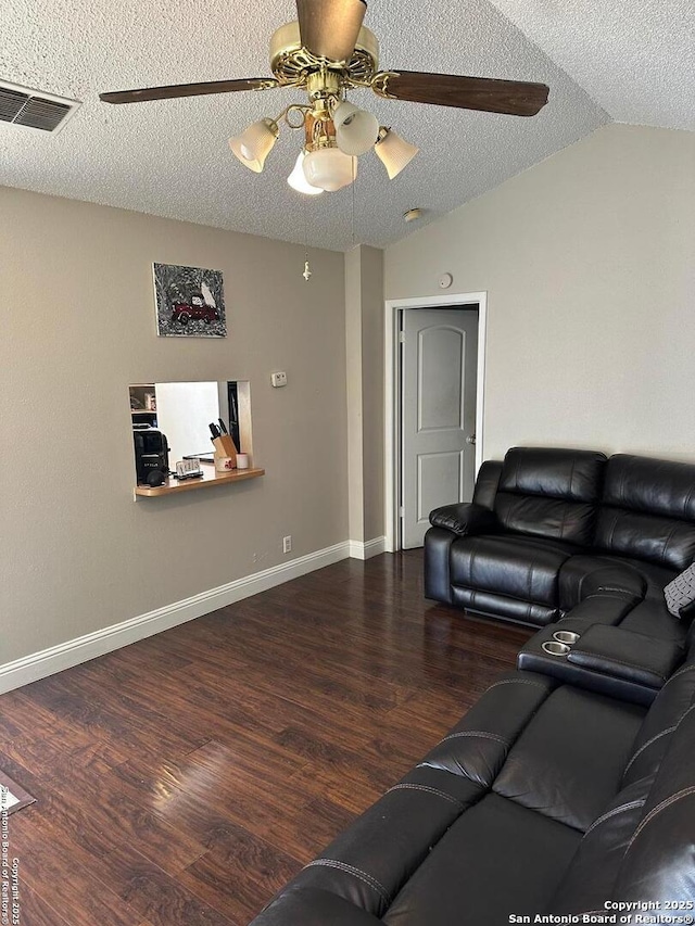 living room featuring a ceiling fan, lofted ceiling, a textured ceiling, visible vents, and wood finished floors