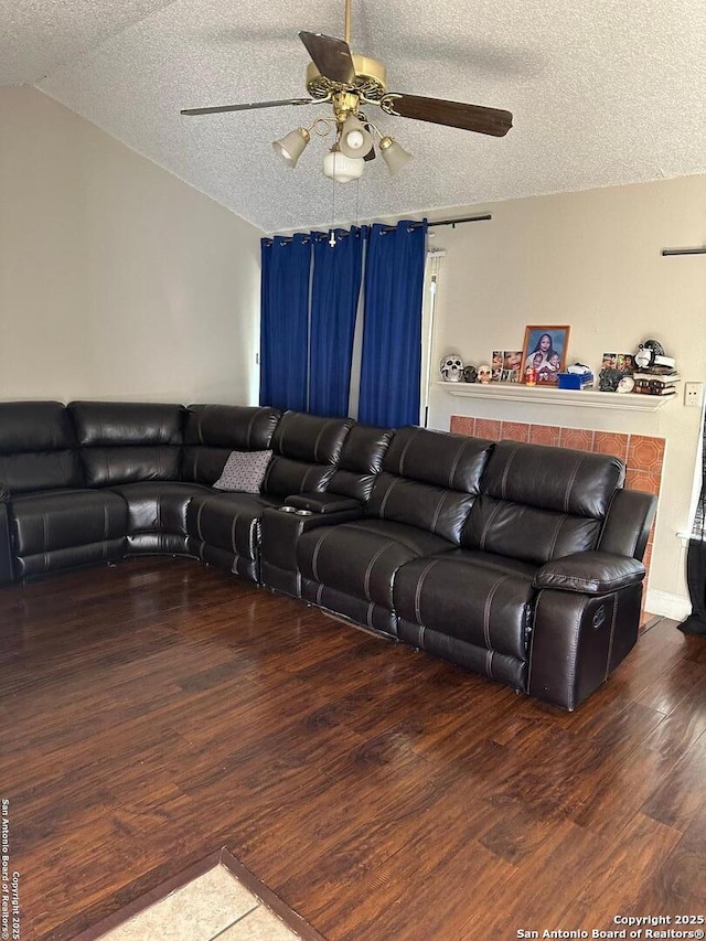 living area featuring a textured ceiling, wood finished floors, and a ceiling fan