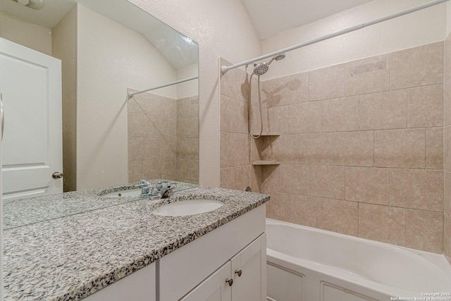 full bathroom with vanity, a textured wall, and bathtub / shower combination
