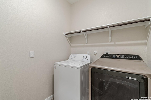 clothes washing area with washer and clothes dryer and laundry area