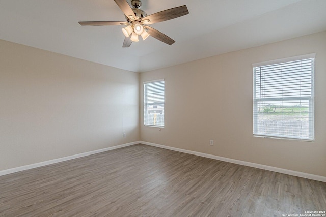 spare room with light wood-style floors, baseboards, and ceiling fan