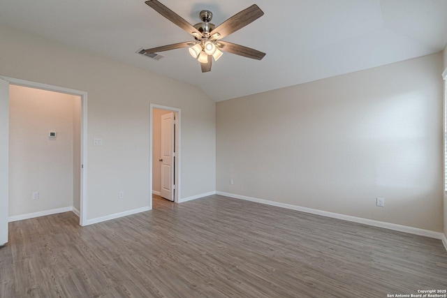unfurnished room featuring wood finished floors, visible vents, vaulted ceiling, a ceiling fan, and baseboards