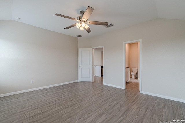 unfurnished bedroom featuring lofted ceiling, baseboards, visible vents, and wood finished floors