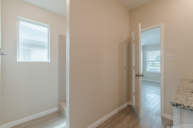 hall with light wood-style flooring and baseboards