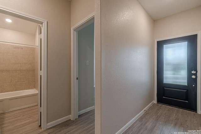 entryway with baseboards and wood finished floors