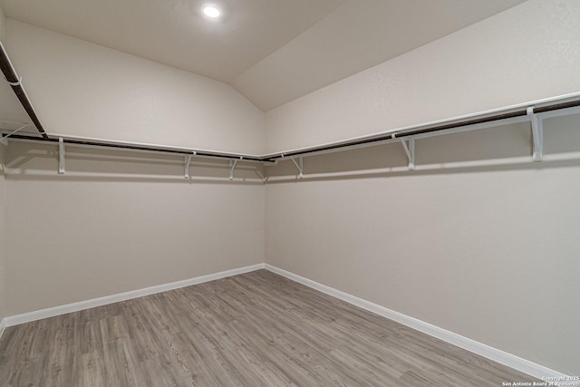 spacious closet with lofted ceiling and wood finished floors