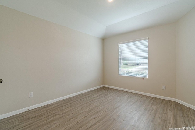 empty room with baseboards and light wood-type flooring