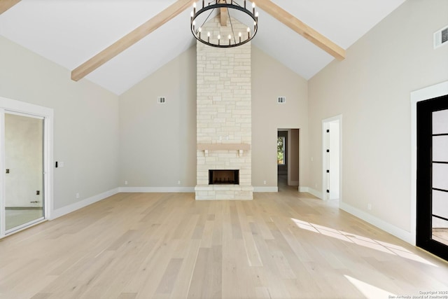 115 Heartland, Boerne, TX 78006 - unfurnished living room featuring high vaulted ceiling, a chandelier, light wood finished floors, beamed ceiling, and a stone fireplace