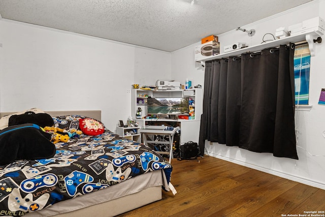 bedroom featuring a textured ceiling and wood finished floors