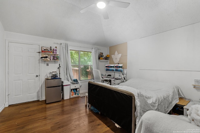 bedroom with freestanding refrigerator, a textured ceiling, wood finished floors, and a ceiling fan