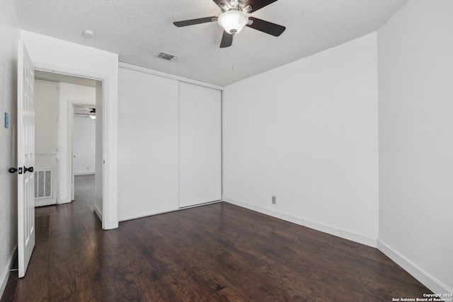 unfurnished bedroom featuring a closet, visible vents, wood finished floors, and baseboards