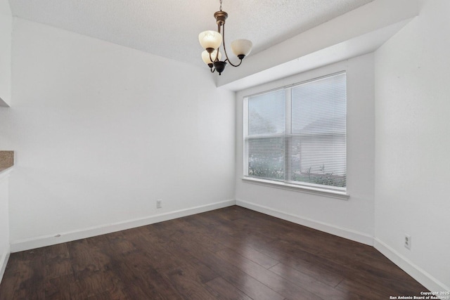 unfurnished dining area featuring a chandelier, baseboards, and dark wood-style floors
