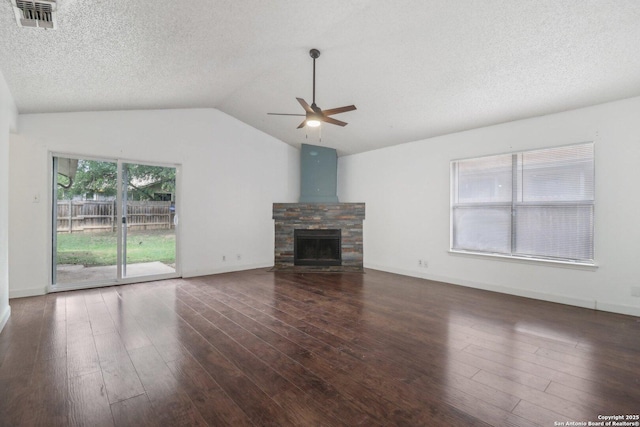 unfurnished living room featuring lofted ceiling, wood finished floors, visible vents, a ceiling fan, and a stone fireplace