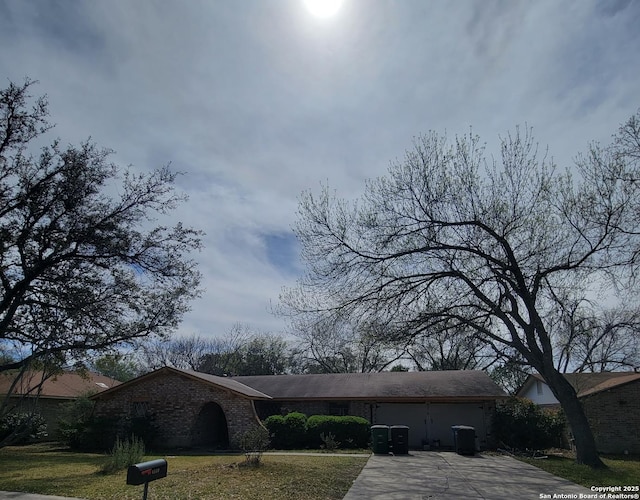 single story home with concrete driveway, a garage, a front lawn, and brick siding