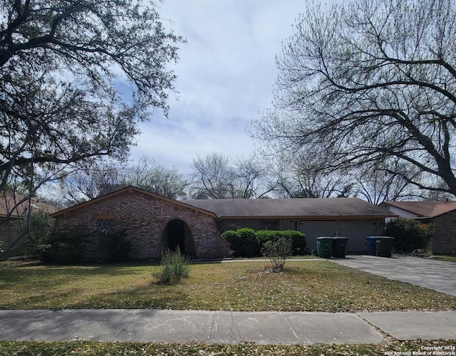 single story home featuring concrete driveway, an attached garage, brick siding, and a front yard